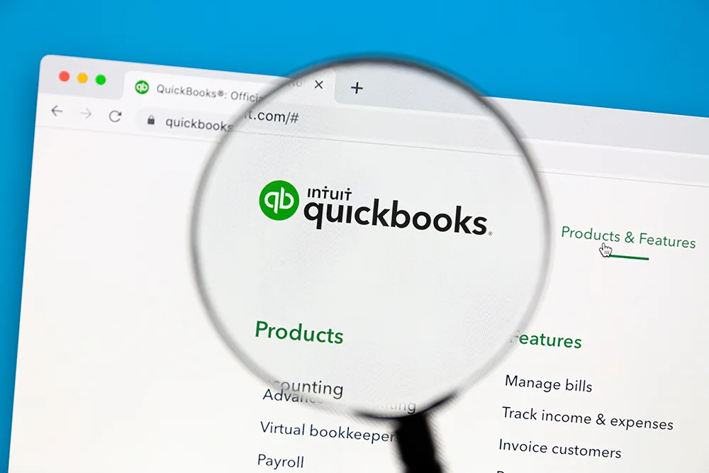 Magnifying glass with view of Quickbooks website on a computer screen